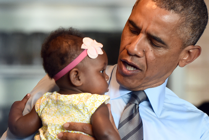 President Barack Obama cradles a baby during a visit to the Charcoal Pit restaurant in Wilmington, Del., on July 17, 2014. JEWEL SAMAD/AFP/Getty Images